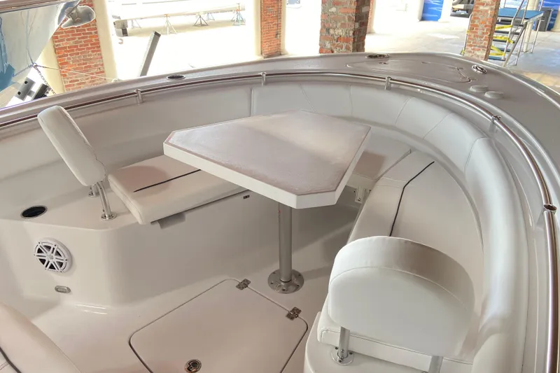 Slide: The Image of 2026 Sportsman Open 232 Center Console boat interior with seating and table. - 25