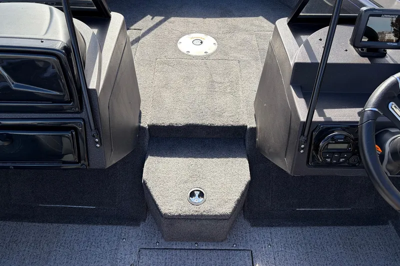 Slide: The Image of 2024 Tracker Targa V-18 Combo boat interior with carpeted flooring and control panel. - 27