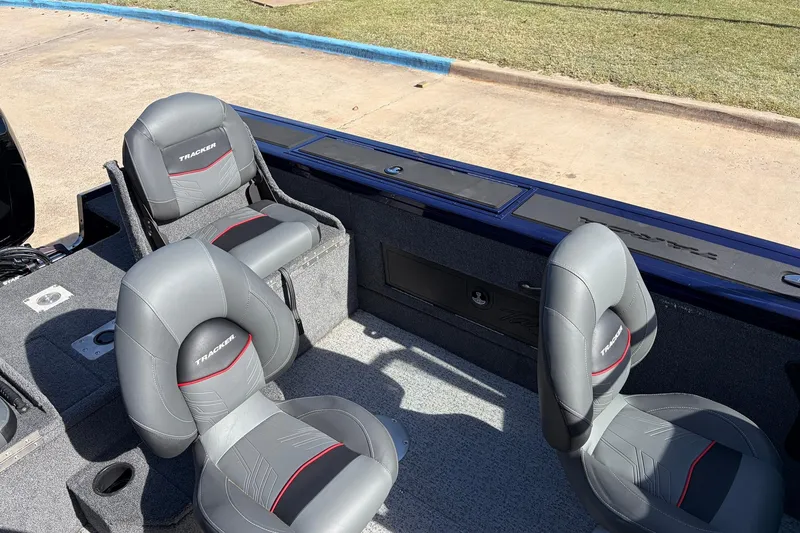 Slide: The Image of 2024 Tracker Targa V-18 Combo boat interior with gray and red cushioned seats. - 36