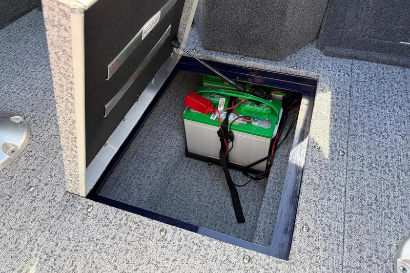 Slide: The Image of Battery compartment of 2024 Tracker Targa V-18 Combo boat, featuring a green marine battery. - 49
