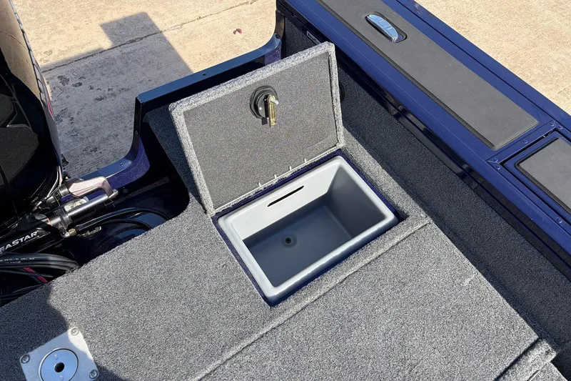 Slide: The Image of 2024 Tracker Targa V-18 Combo boat with open storage compartment and carpeted deck. - 55
