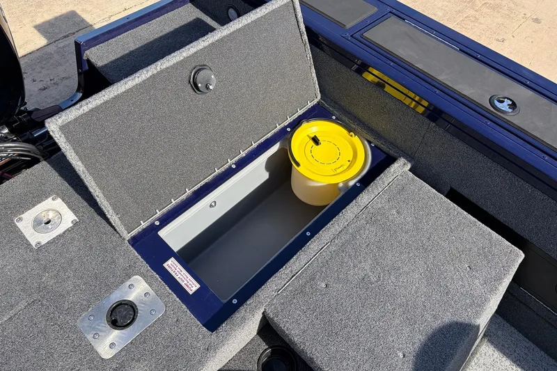 Slide: The Image of 2024 Tracker Targa V-18 Combo boat storage compartment with yellow bucket. - 56