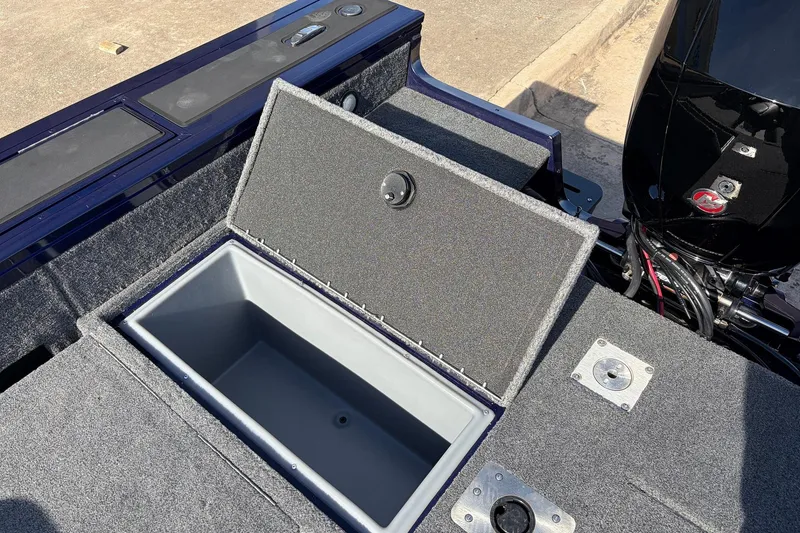 Slide: The Image of 2024 Tracker Targa V-18 Combo boat with open storage compartment and motor. - 57