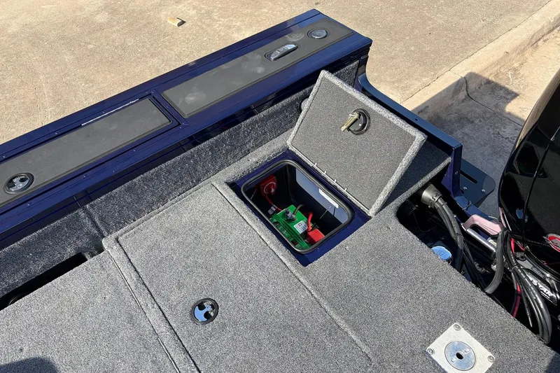 Slide: The Image of 2024 Tracker Targa V-18 Combo boat with open storage compartment and visible battery. - 58