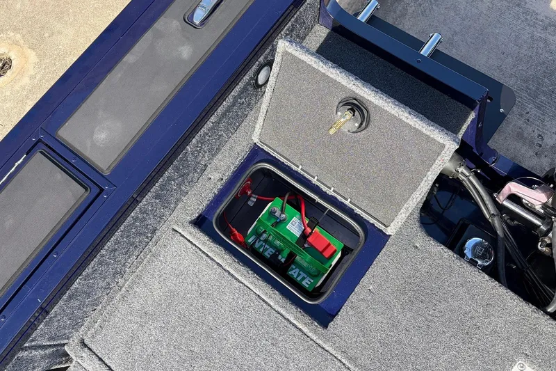 Slide: The Image of 2024 Tracker Targa V-18 Combo boat battery compartment with secure storage. - 59