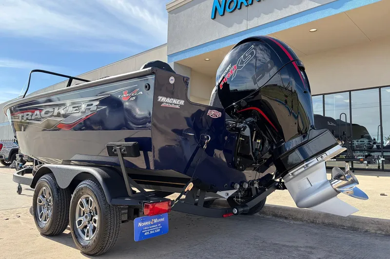 Slide: The Image of 2024 Tracker Targa V-18 Combo boat with powerful outboard motor, parked outside dealership. - 7
