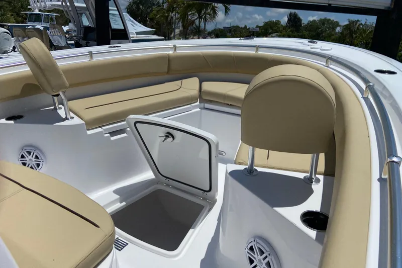 Slide: The Image of 2026 Sportsman Heritage 231 Center Console boat interior with beige seating and storage compartment. - 26