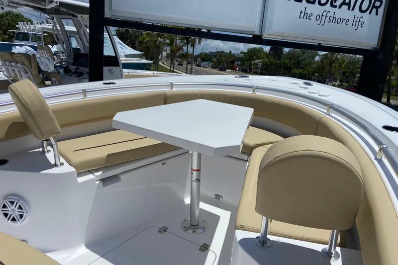 Slide: The Image of 2026 Sportsman Heritage 231 Center Console boat with beige seating and white table. - 27