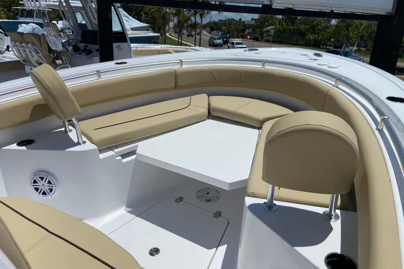 Slide: The Image of 2026 Sportsman Heritage 231 Center Console boat with beige seating and white table. - 28