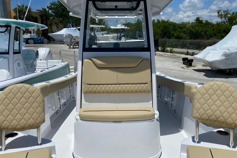 Slide: The Image of 2026 Sportsman Heritage 231 Center Console boat with tan seating, docked outdoors. - 30