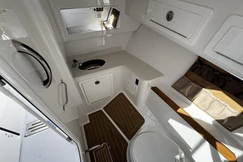 Slide: The Image of 2026 Southport 33 DC boat interior with modern bathroom, featuring sink, toilet, and storage. - 10
