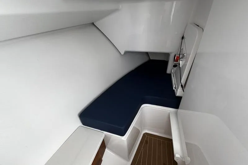 Slide: The Image of 2026 Southport 33 DC cabin interior with blue seating and wooden flooring. - 16