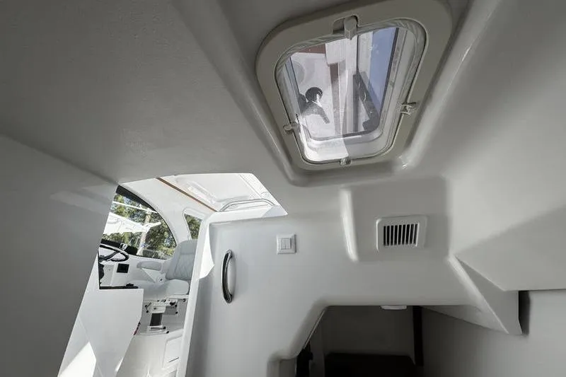 Slide: The Image of Interior view of 2026 Southport 33 DC boat cabin with hatch and seating area. - 17