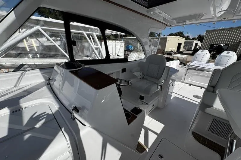 Slide: The Image of 2026 Southport 33 DC boat interior with helm station and seating area. - 18
