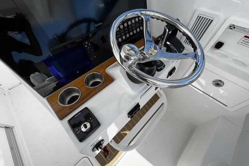 Slide: The Image of Steering console of 2026 Southport 33 DC boat with modern controls and wood accents. - 22