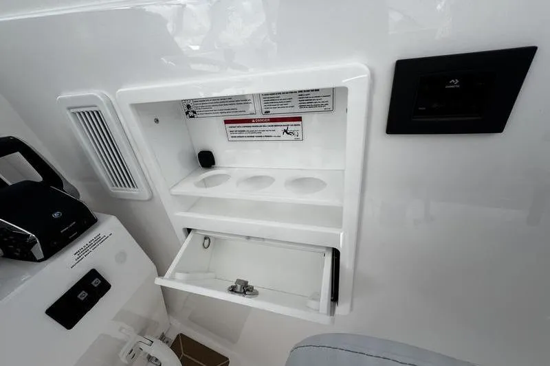 Slide: The Image of 2026 Southport 33 DC boat interior with storage compartment and control panel. - 24