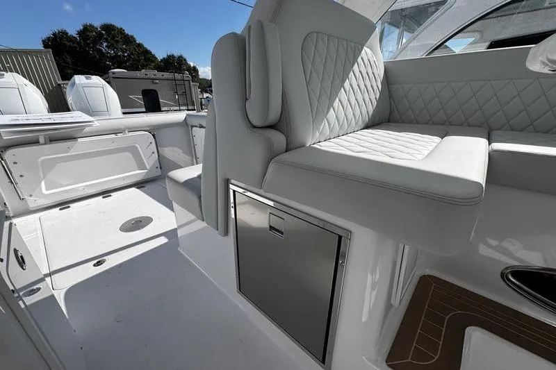 Slide: The Image of 2026 Southport 33 DC boat interior with white seating and storage compartment. - 25