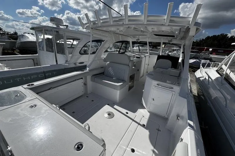 Slide: The Image of 2026 Southport 33 DC boat interior with seating and storage under a cloudy sky. - 32