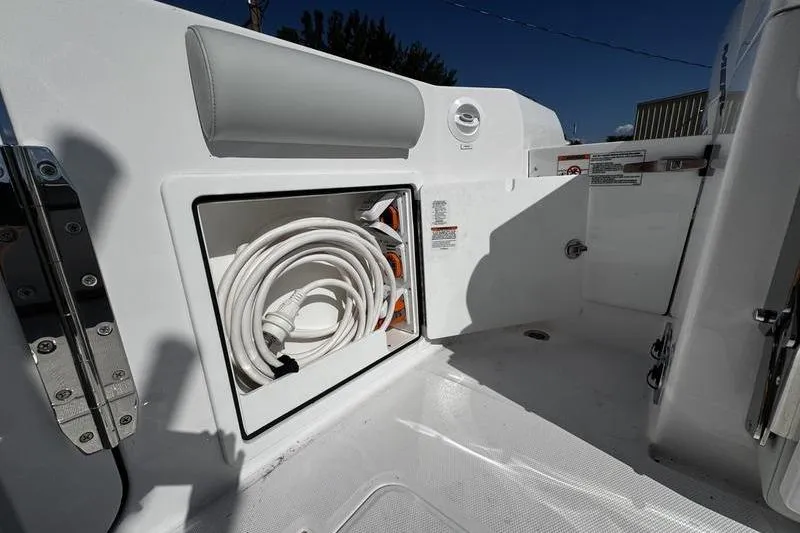 Slide: The Image of 2026 Southport 33 DC boat storage compartment with coiled hose and sleek design. - 39