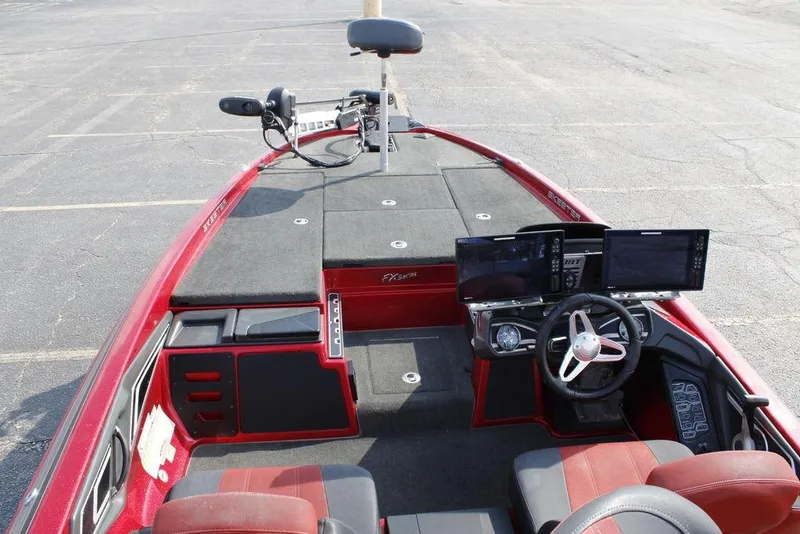 Slide: The Image of 2016 Skeeter FX20 boat interior with dual screens and steering wheel in a parking lot. - 14
