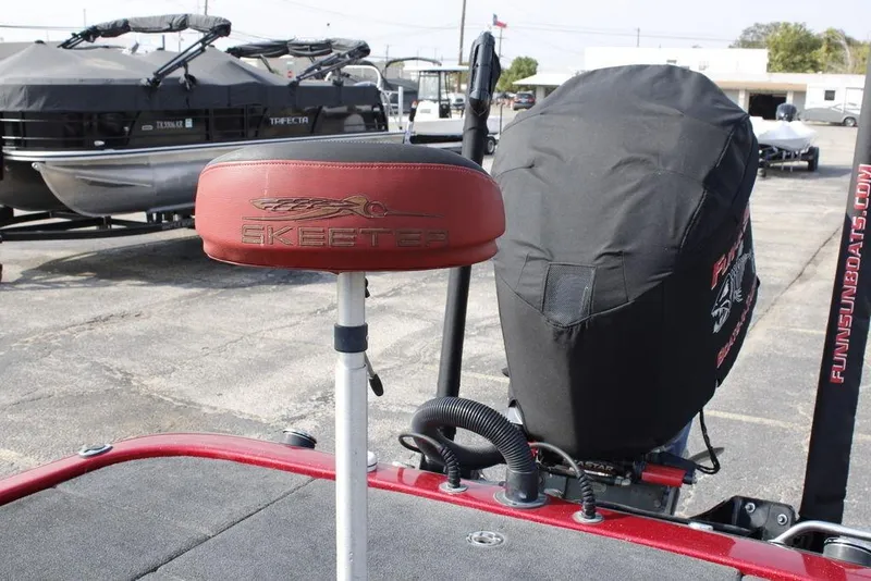 Slide: The Image of 2016 Skeeter FX20 boat seat and engine cover in a parking lot. - 20