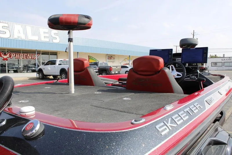 Slide: The Image of 2016 Skeeter FX20 bass boat with red seats and dual monitors at a dealership. - 22