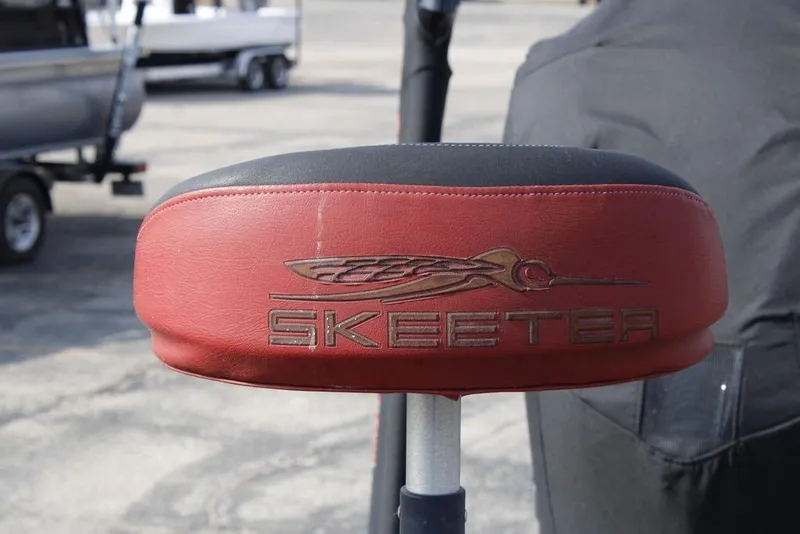 Slide: The Image of Red Skeeter FX20 boat seat, 2016 model, with logo in outdoor setting. - 24
