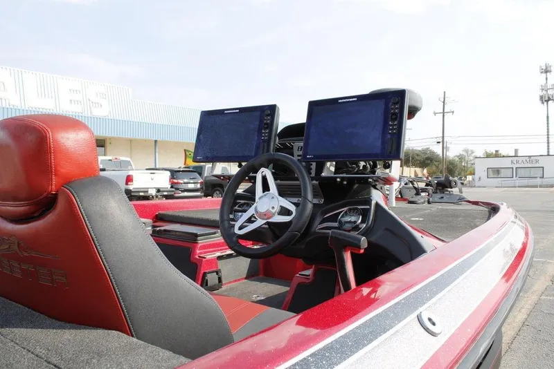Slide: The Image of 2016 Skeeter FX20 boat interior with dual navigation screens and red seating. - 25