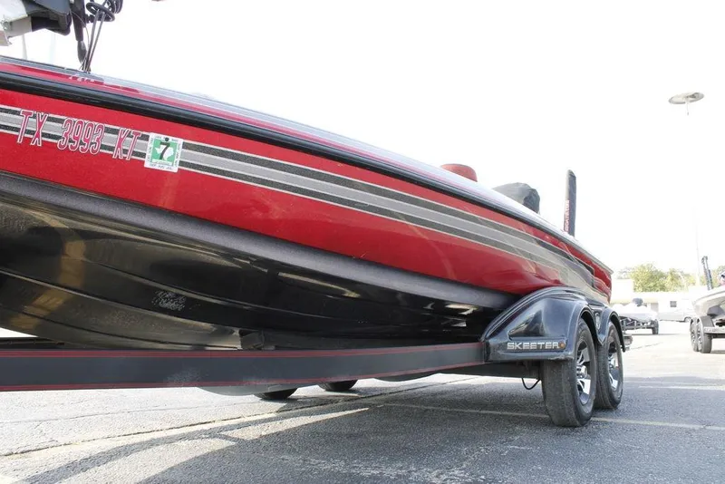 Slide: The Image of 2016 Skeeter FX20 boat on trailer, red and black design, side view. - 32