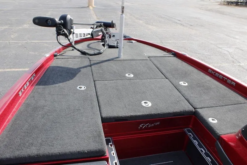 Slide: The Image of 2016 Skeeter FX20 boat deck with trolling motor, red finish, and storage compartments. - 34