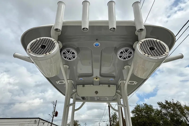 Slide: The Image of 2019 Sportsman Heritage 211 Center Console boat speakers and rod holders under T-top. - 11