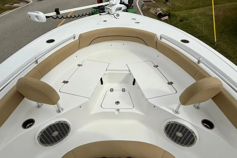 Slide: The Image of 2019 Sportsman Heritage 211 Center Console boat interior with tan seating and storage compartments. - 13