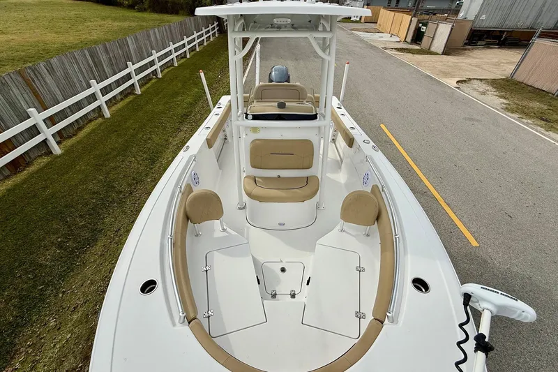 Slide: The Image of 2019 Sportsman Heritage 211 Center Console boat with beige seating, docked on a paved road. - 15