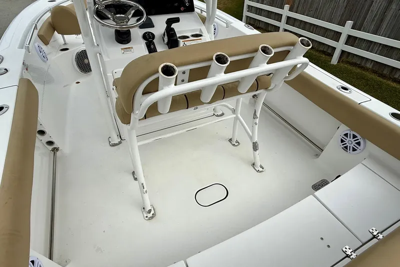 Slide: The Image of 2019 Sportsman Heritage 211 Center Console boat interior with beige seating and rod holders. - 8