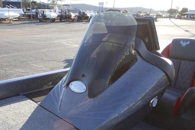 Slide: The Image of 2026 Phoenix 721 boat cockpit with windshield and seating, parked outdoors. - 18