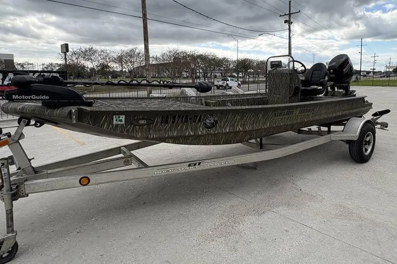 Slide: The Image of 2013 Gator Trax 17X54 boat on trailer, featuring camo design and MotorGuide trolling motor. - 2