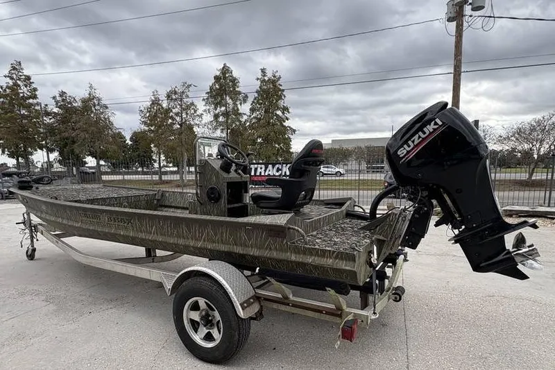 Slide: The Image of 2013 Gator Trax 17X54 boat with Suzuki outboard motor on trailer, parked outdoors. - 3