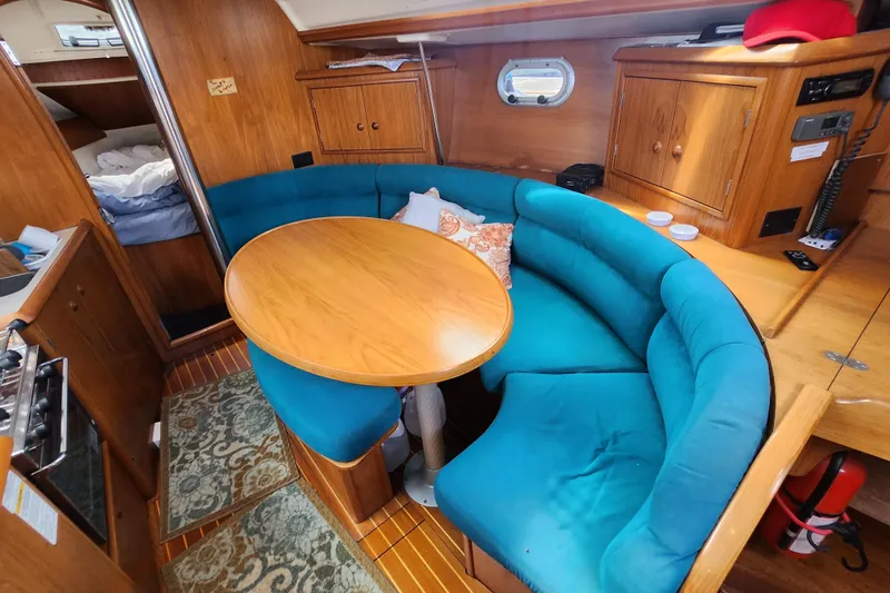 Slide: The Image of Interior of 2001 Jeanneau Sun Odyssey 34.2 sailboat with blue seating and wooden table. - 18