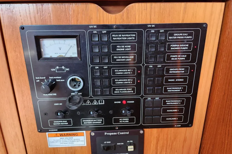 Slide: The Image of Control panel of a 2001 Jeanneau Sun Odyssey 34.2 sailboat, featuring various switches and a voltmeter. - 23