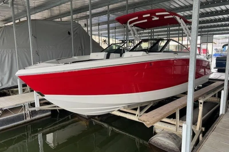 The Image of 2021 Cobalt R8 boat in red and white, docked in a covered marina. - 1