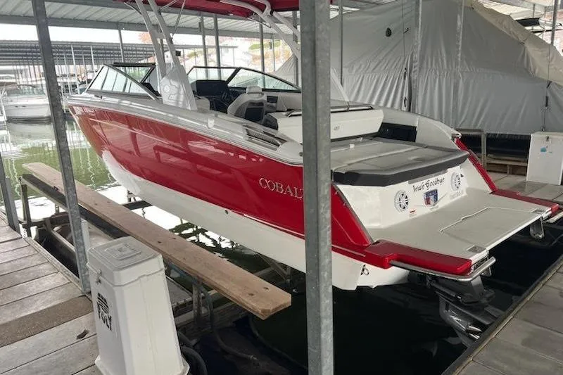 Slide: The Image of 2021 Cobalt R8 boat in a marina, featuring a sleek red and white design. - 13