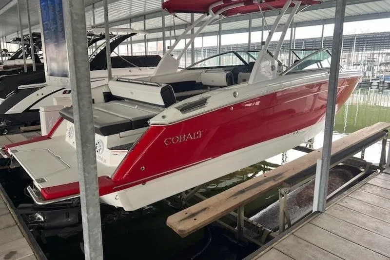 Slide: The Image of 2021 Cobalt R8 boat in red and white, docked in a covered marina. - 3