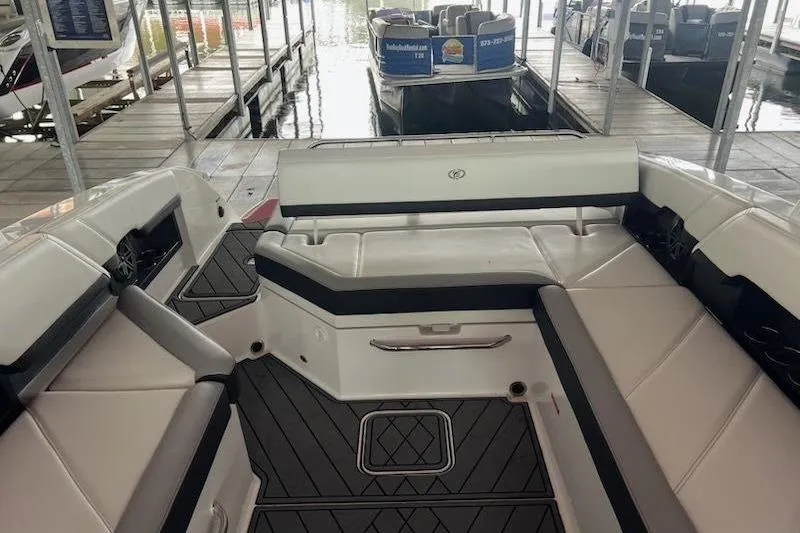 Slide: The Image of 2021 Cobalt R8 boat interior with white seating and black accents at a marina. - 4