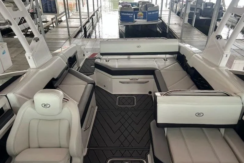 Slide: The Image of 2021 Cobalt R8 boat interior with white seating and sleek design at a marina. - 6