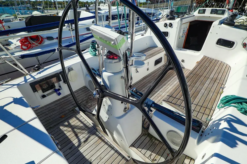 Slide: The Image of 2005 J Boats J/133 sailboat cockpit with large steering wheel and teak decking. - 13