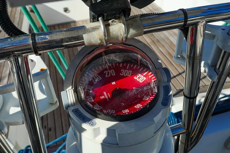 Slide: The Image of Compass on 2005 J Boats J/133 yacht, surrounded by metal railings and deck ropes. - 15