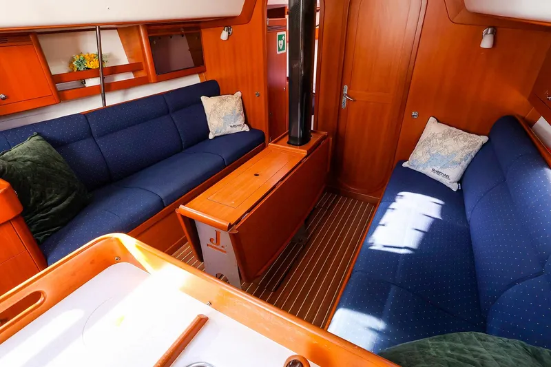 Slide: The Image of Interior of 2005 J Boats J/133 sailboat with blue seating and wooden finishes. - 19