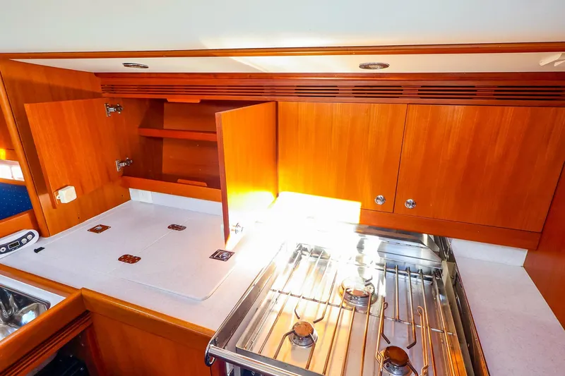 Slide: The Image of 2005 J Boats J/133 yacht kitchen with wooden cabinets and stainless steel stove. - 22