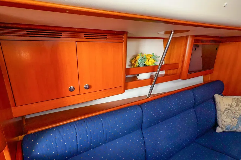 Slide: The Image of Interior of 2005 J Boats J/133 with blue seating and wooden cabinetry. - 23
