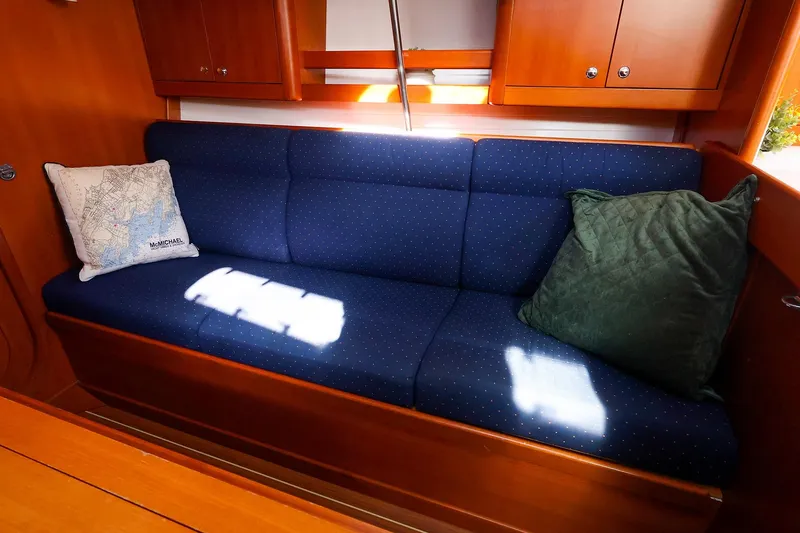 Slide: The Image of Interior of 2005 J Boats J/133 with blue cushioned seating and decorative pillows. - 24